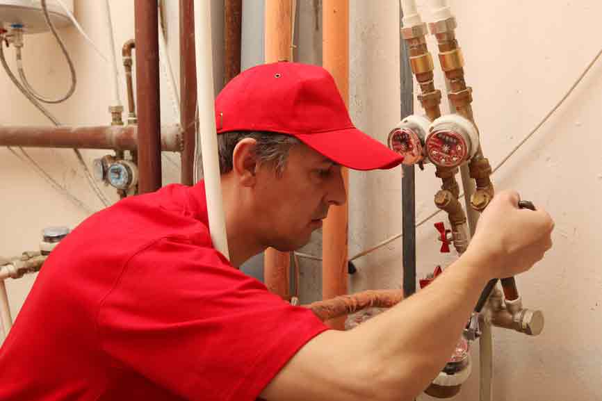 Plumber looking at pipes